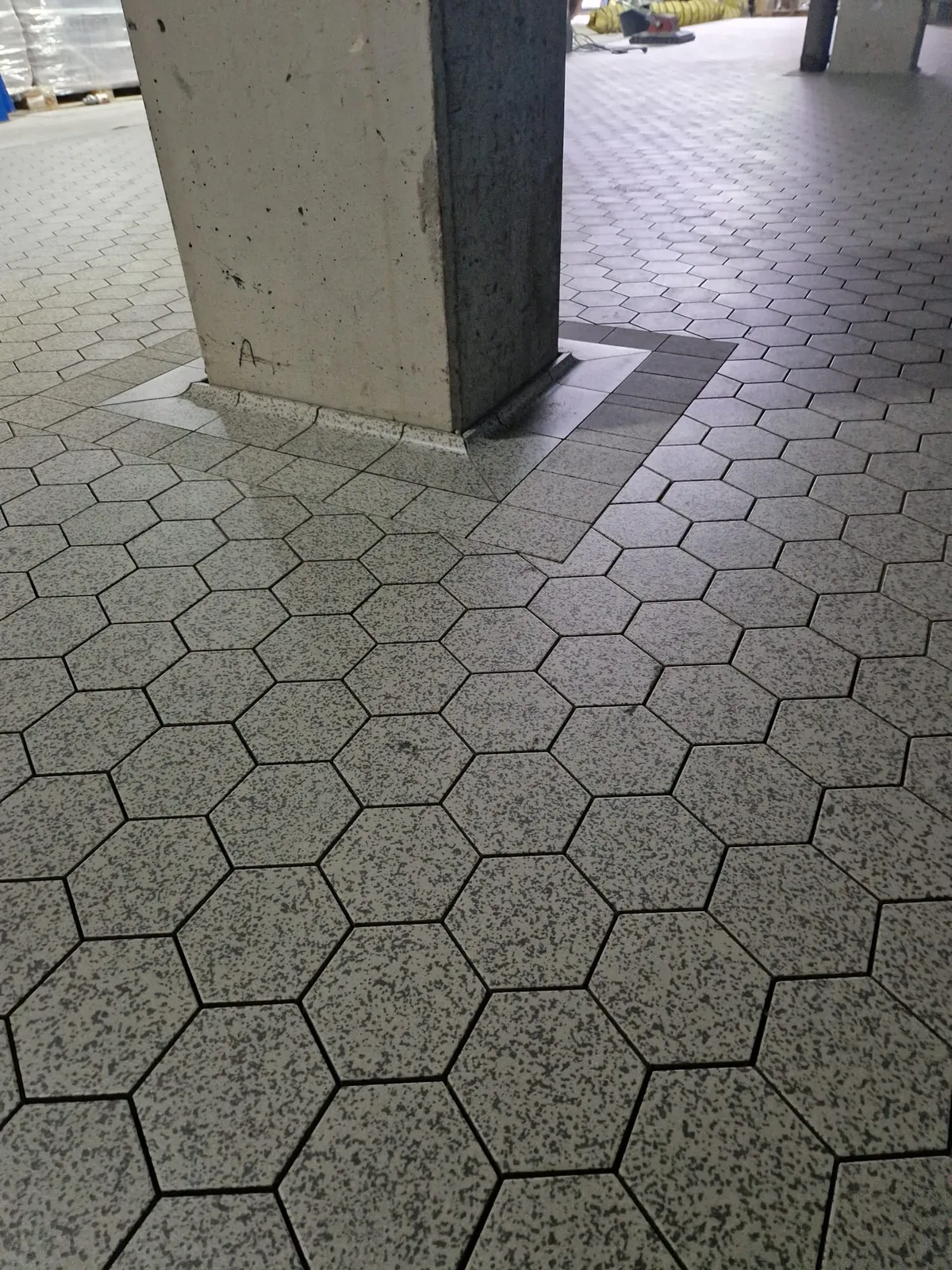 Sauberer Bodenanschluss an einer Hallenstütze im Sechskant-Keramikboden
